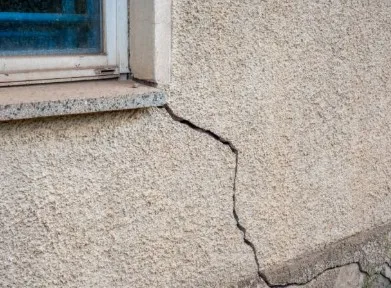 mage showing a medium sized crack in a stucco wall meant to describe contractor  stucco repair services in Santa Fe NM area